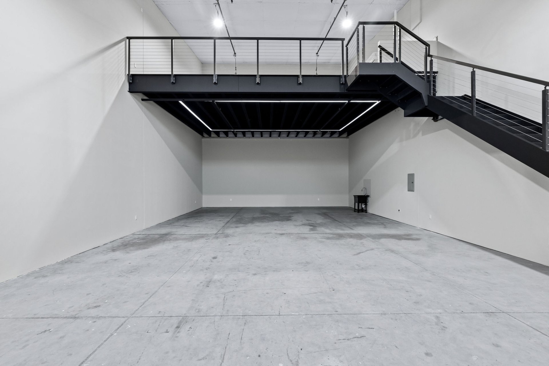 Empty GOTA unit interior showing the mezzanine and cable rail staircase