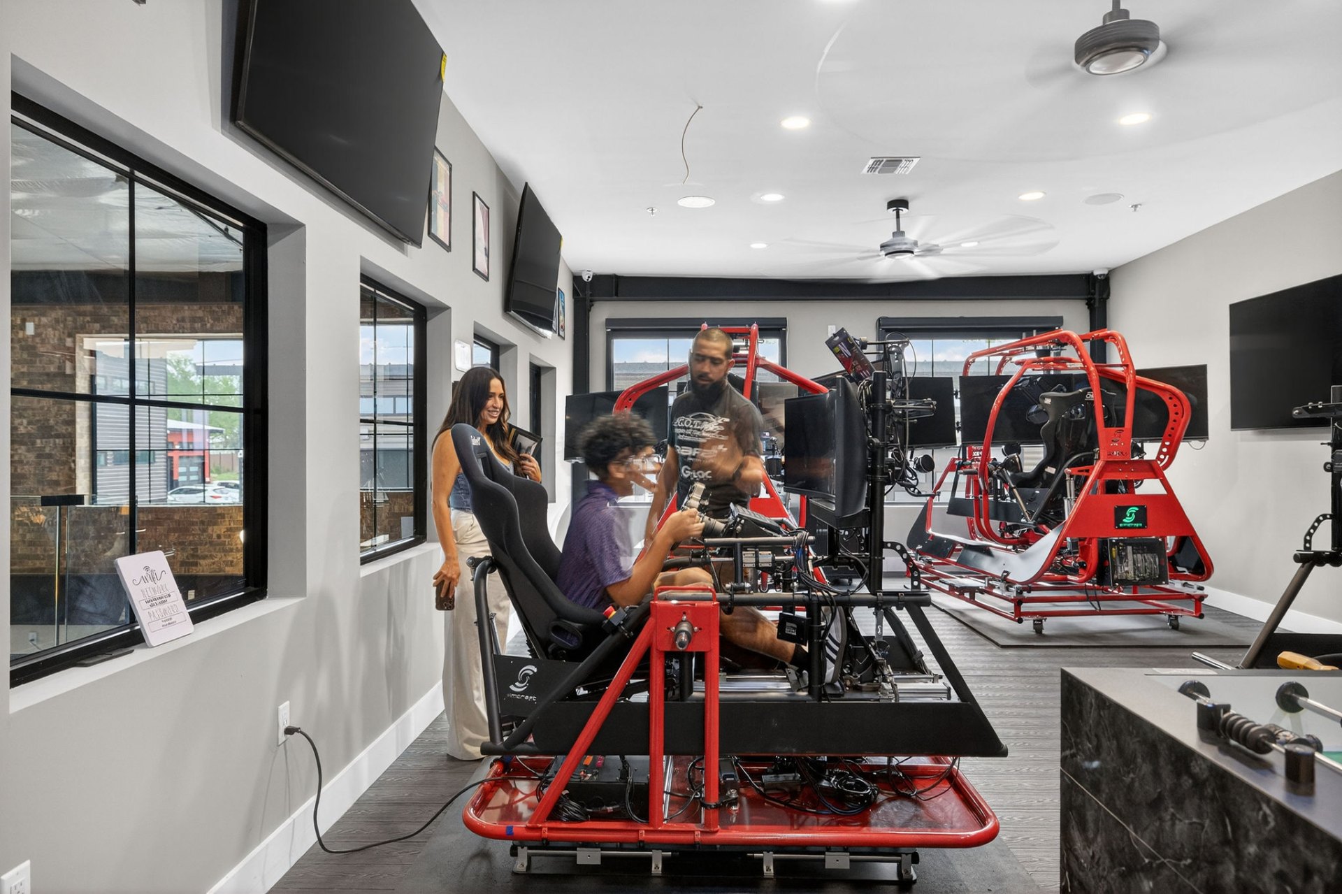 Owners using professional sim racing rigs inside the clubhouse
