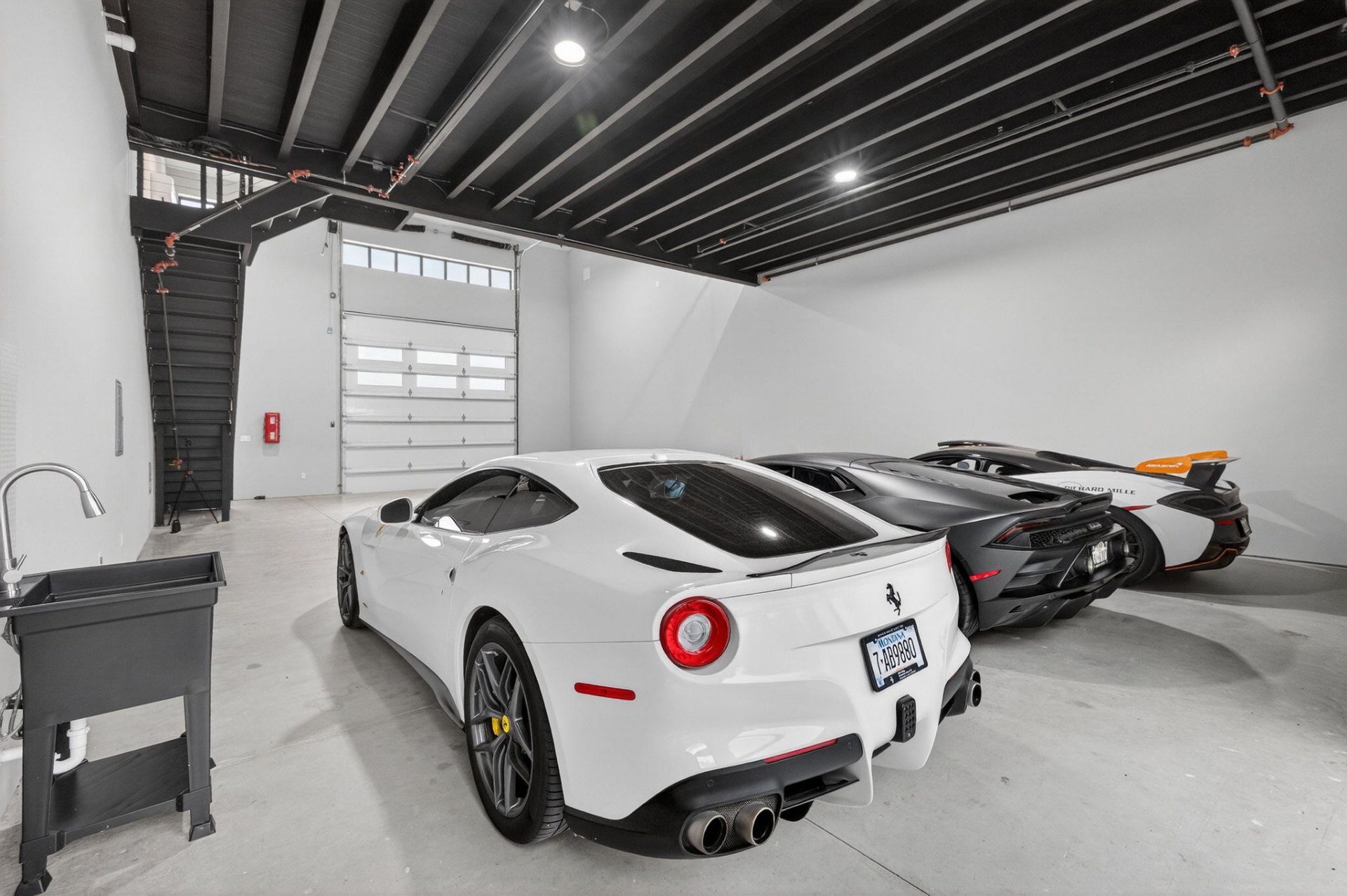 White Ferrari, Lamborghini and McLaren parked inside a GOTA unit