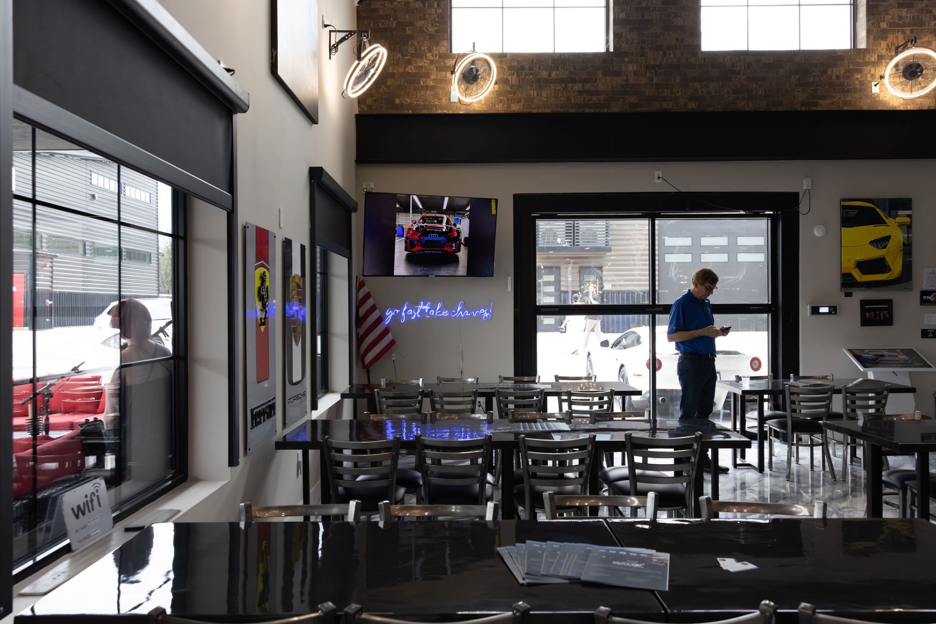 GOTA cafe seating with Ferrari and Porsche art and neon signage