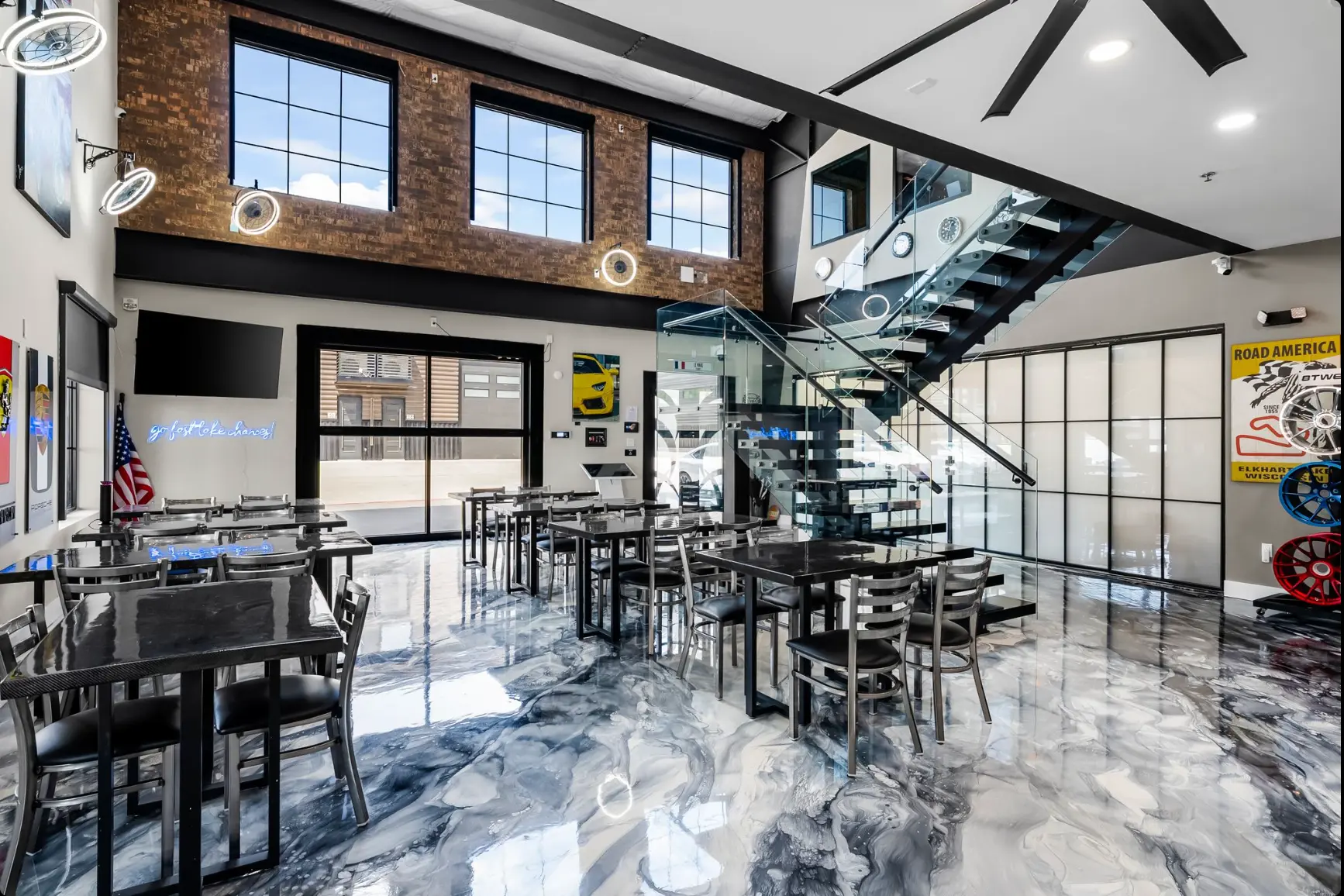 Clubhouse cafe with glass staircase and racing artwork
