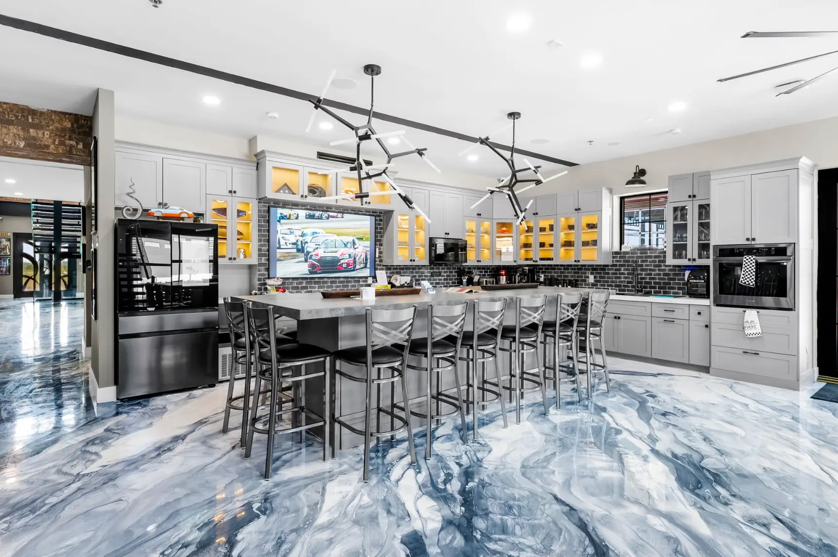 Clubhouse kitchen with large island, bar seating and epoxy marble floor
